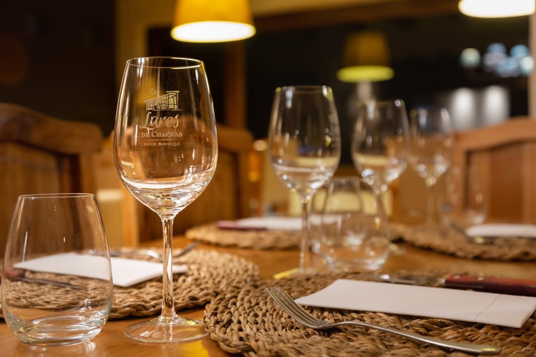 Mesa puesta en el salón de Lares Cocina de Hogar, con copas grabadas con el logo de Lares